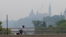 A cyclist makes their way along a bike path into the downtown core wearing a mask, Wednesday, June 7, 2023 in Ottawa. (Adrian Wyld/THE CANADIAN PRESS)