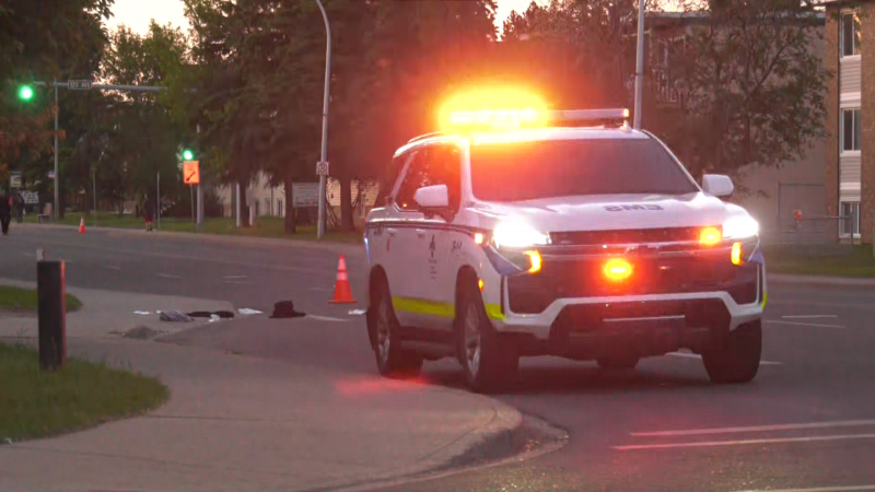 On June 6, 2023, personal items lay on the street behind an EMS vehicle at the intersection of 82 Street and 122 Avenue, where a man was seriously hurt in a hit-and-run. (CTV News Edmonton / Sean Amato)