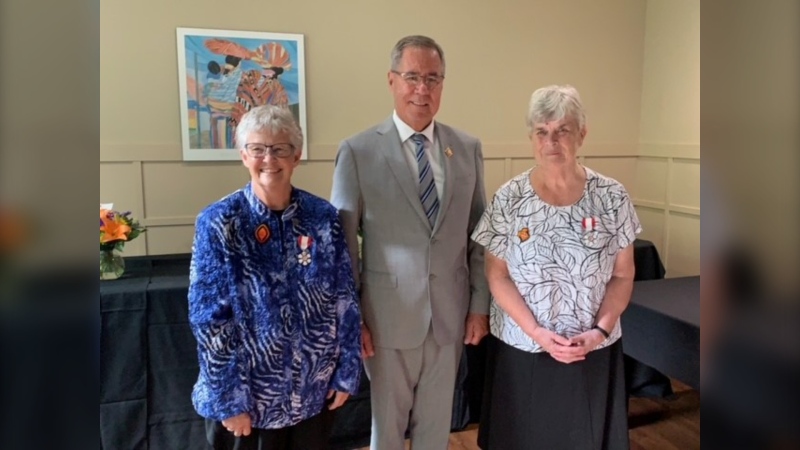 Margaret Hughes (left), Lieutenant Governor of Saskatchewan Russ Mirasty, and Bernadette O’Reilly pose for a photo on June 6, 2023 in Saskatoon. Hughes and O'Reilly, both members of the Sisters of Sion, were inducted into the Order of Canada for their work with Rossbrook house in Winnipeg over 40 years. (Submitted photo)