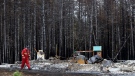 A firefighter walks past a home destroyed by a wildfire in Hammond's Plains, N.S., during a media tour, Tuesday, June 6, 2023. THE CANADIAN PRESS/POOL, Tim Krochak