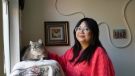Celina Chanthanouvong stands with her cat in her apartment in Emeryville, Calif., on June 2, 2023. After a payment pause that has lasted more than three years, more than 40 million student loan borrowers will be on the hook for payments starting in late August. The pause in repayment has been a lifeline keeping 25-year-old Chanthanouvong afloat. (AP Photo/Terry Chea)