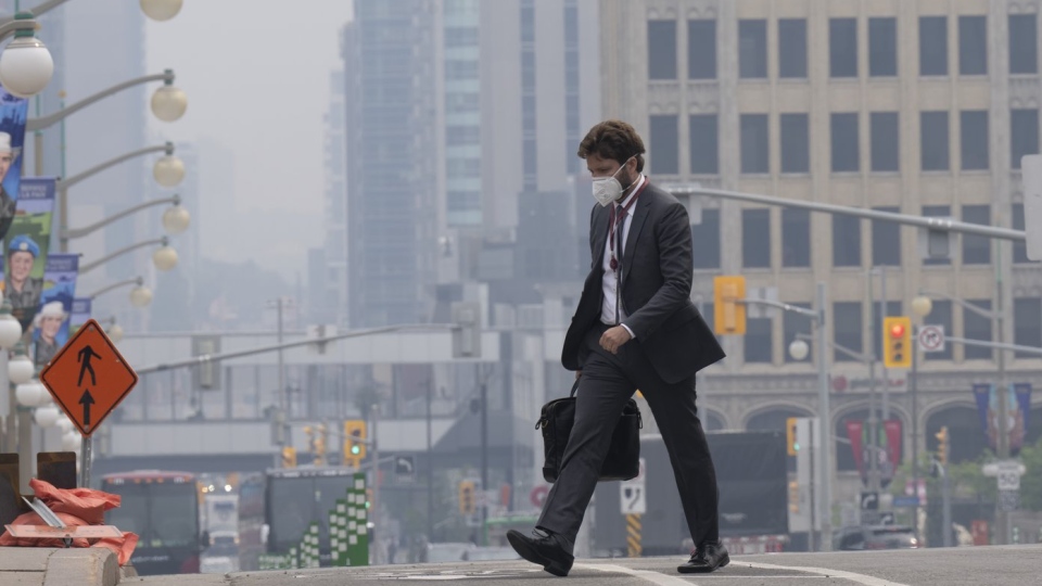 A man walks to work wearing a mask