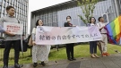 Lawyers unfurl a banner, which reads 'Marriage freedom for all,' before a ruling outside the Fukuoka District Court in Fukuoka, southern Japan Thursday, June 8, 2023. (Kyodo News via AP)