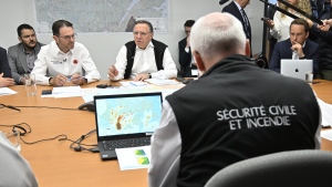 Quebec Premier François Legault speaks to officials while forest fires are raging as he visits the crisis operation centre in Quebec City, Wednesday, June 7, 2023. Quebec's wildfire fight is focused today again in the province's northern regions where fires have reached the doorstep of a small municipality in the western Abitibi region. THE CANADIAN PRESS/Jacques Boissinot
