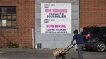 A 'Now Hiring,' sign is displayed on a business Tuesday, May 30, 2023 in Montreal. (THE CANADIAN PRESS/Christinne Muschi)