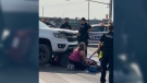 A bystander helps a woman after the scooter she was on was struck by a truck on Wharncliffe Road near Southdale Road.