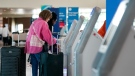 Travelers use the kiosk by the ticketing gate as they prepare for travel from Love Field airport, May 19, 2023, in Dallas. (AP Photo/Tony Gutierrez, File)