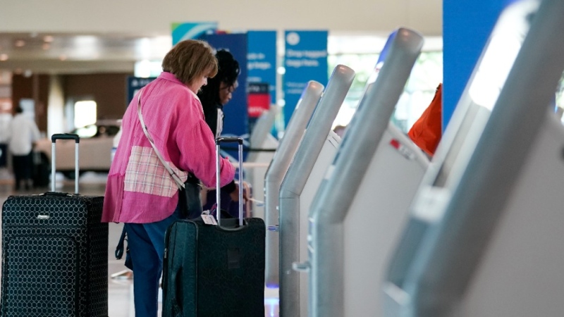 Travelers use the kiosk by the ticketing gate as they prepare for travel from Love Field airport, May 19, 2023, in Dallas. (AP Photo/Tony Gutierrez, File)