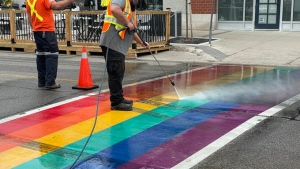Crews work to clean a rainbow crosswalk in the City of Waterloo that was streaked with tire marks. (City of Waterloo/Twitter)
