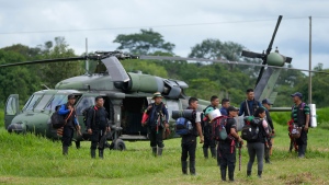 Indigenous men wait to board an helicopter at a military base in Calamar, Colombia, Tuesday, May 23, 2023, to help in the search of four Indigenous children that are missing after a deadly plane crash. Colombian troops found the wreckage of the plane on May 16 along with the bodies of the pilot, a guide and the children's mother, but there was no sign of the youngsters. (AP Photo/Fernando Vergara)