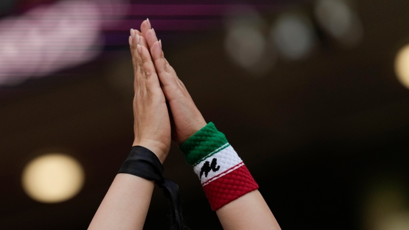 A soccer fan wears a black ribbon in her wrist in memory of Mahsa Amini, a woman who died while in police custody in Iran, prior to the World Cup group B soccer match between Wales and Iran, at the Ahmad Bin Ali Stadium in Al Rayyan , Qatar, Friday, Nov. 25, 2022. (AP Photo/Francisco Seco)