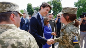 Prime Minister Justin Trudeau speaks with Ukrainian soldiers as he visits the Wall of Remembrance, in Kyiv, Ukraine, June 10, 2023. (Valentyn Ogirenko/Pool via AP)
