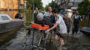 Volunteers haul a woman on a stretcher as she been evacuated from a flooded neighborhood of the left bank Dnipro river, in Kherson, Ukraine, Friday, June 9, 2023. (AP Photo/Evgeniy Maloletka)