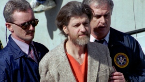 Ted Kaczynski, better known as the Unabomber, is flanked by federal agents as he is led to a car from the federal courthouse in Helena, Mont., April 4, 1996. (AP Photo/John Youngbear, File)