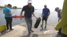 Volunteer Derek Evans pulls a small tire out of the waters of Lake Ontario during 'Kingston Waters Clean Up.' (Kimberley Johnson/CTV News Ottawa)
