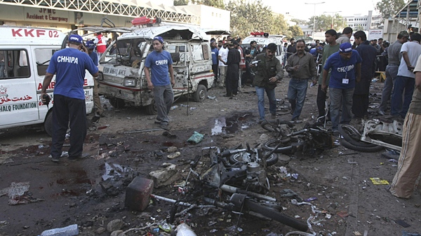 People look at the spot of a bomb blast outside a hospital emergency ward where victims of earlier blast were brought for treatment in Karachi, Pakistan, Friday, Feb. 5, 2010. (AP / Fareed Khan)