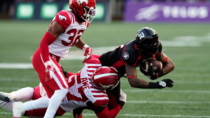 Ottawa Redblacks wide receiver Justin Hardy (2) is tackled by Calgary Stampeders linebacker Micah Awe (57) and defensive back Titus Wall (32) during first half CFL football action in Ottawa on Thursday, June 15, 2023. (Adrian Wyld/THE CANADIAN PRESS) 
