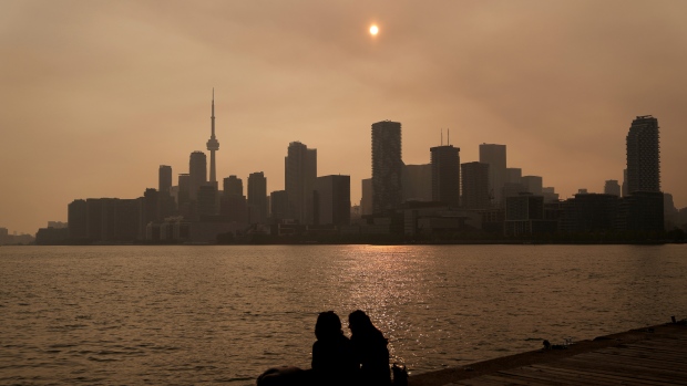 People watch the sunset as the smoke from wildfires is visible in Toronto on Wednesday, June 28, 2023. (Chris Young / The Canadian Press via AP)