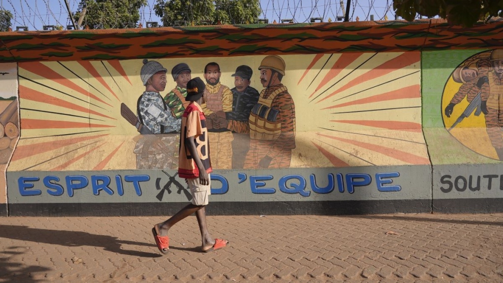 A man walks past a mural in Ouagadougou, Burkina F
