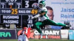 Saskatchewan Roughriders running back Jamal Morrow, right, leaps away from Calgary Stampeders defensive back Tre Roberson during first half CFL football action in Calgary, Alta., Saturday, June 24, 2023. THE CANADIAN PRESS/Jeff McIntosh