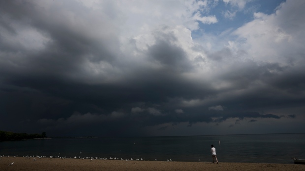 FILE - A person looks out over Lake Ontario as a thunderstorm rolls through in Toronto on Thursday, August 4, 2022. THE CANADIAN PRESS/Nathan Denette 