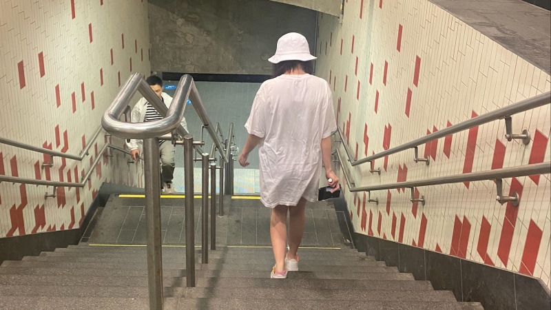 A woman walks down to the Beaudry metro station in Montreal on Tuesday, July 18, 2023. A viral trend on TikTok shows how women are wearing oversized shirts on public transit to avoid harassment. (Jessica Barile/CTV News)