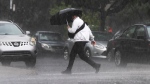 A pedestrian runs through a rainstorm in Montreal. (THE CANADIAN PRESS/Ryan Remiorz)