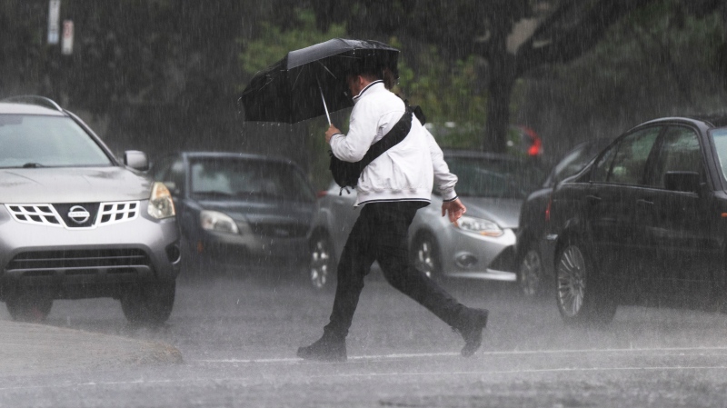 A pedestrian runs through a rainstorm in Montreal. (THE CANADIAN PRESS/Ryan Remiorz)