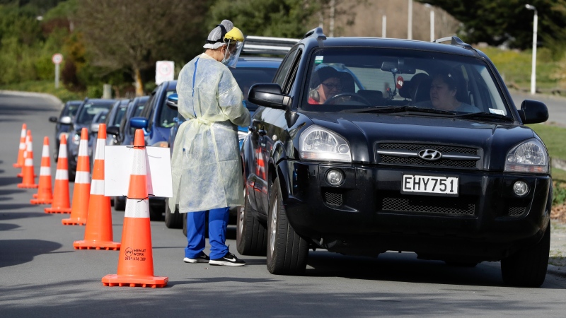 Medical staff prepare take a COVID-19 test from a visitor to a drive through community based assessment centre in Christchurch, New Zealand, Thursday, Aug. 13, 2020. (AP Photo/Mark Baker)