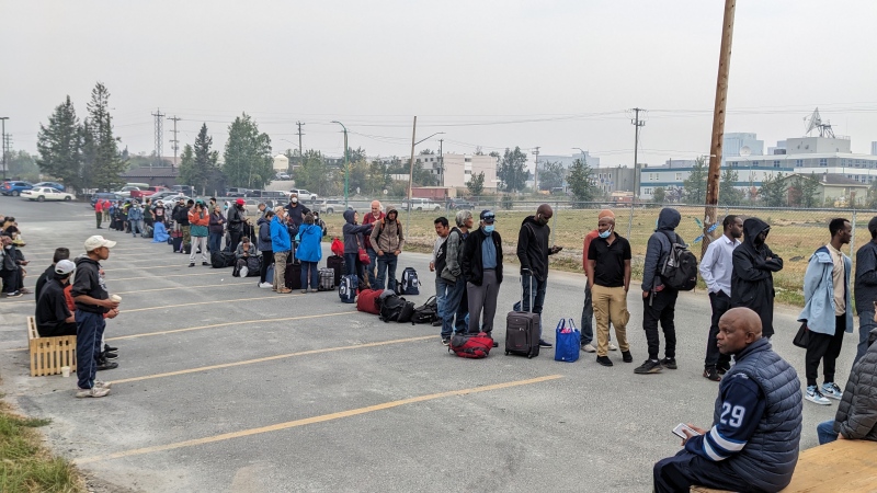 People without vehicles lineup to register for a flight to Calgary, Alberta in Yellowknife on Thursday, August 17, 2023. Prime Minister Justin Trudeau is expected to convene an urgent meeting with ministers and senior officials today as residents of the capital of Northwest Territories are ordered to evacuate the area because of an encroaching wildfire. THE CANADIAN PRESS/Bill Braden