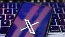 A laptop keyboard and Twitter X logo displayed on a phone screen are seen in this illustration photo taken in Warsaw, Poland, on July 26. (Jakub Porzycki/NurPhoto/Getty Images)