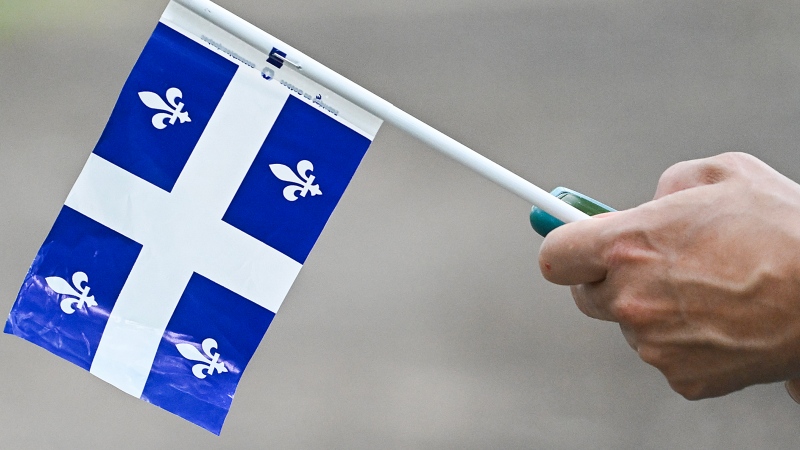A person holds a Quebec flag on Saint-Jean-Baptiste day in Montreal, Saturday, June 24, 2023. THE CANADIAN PRESS/Graham Hughes