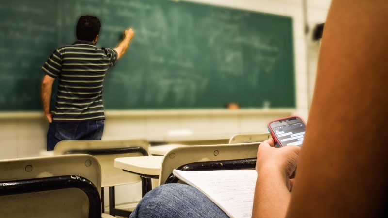 A student uses a mobile phone in a classroom. FILE PHOTO SOURCE: Pexels