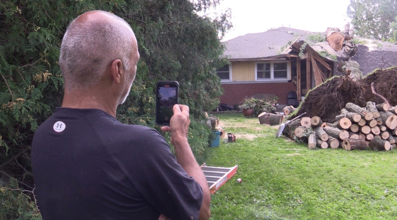 Nick Kamarlingos records video of a tree being removed from on top of his home in Chatham, Ont. on Aug. 26, 2023. (Brent Lale/CTV News London)