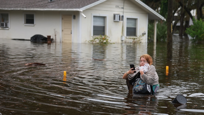 Makatla Ritchter wades through flood waters after having to evacuate her home when the flood waters from Hurricane Idalia inundated it on Aug. 30, 2023 in Tarpon Springs, Fla. (Photo by Joe Raedle/Getty Images)