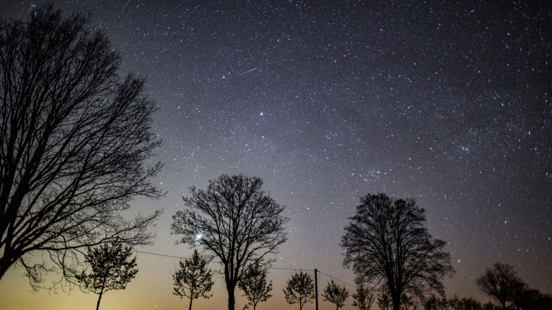 The starry sky shines in the night over an avenue in Petersdorf, eastern Germany, Monday, April 29, 2020. Mont Tremblant National Park has received official Dark Sky certification. (Patrick Pleul/dpa via AP)