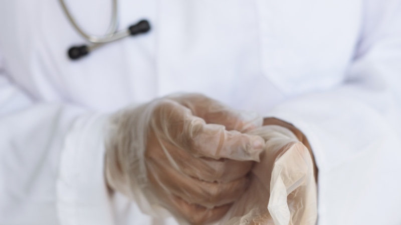 FILE: A doctor puts on her gloves. (RF._.studio via Pexels)