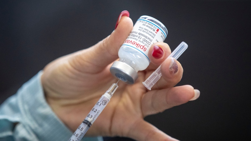 A person draws out Moderna vaccine during a drive through COVID-19 vaccine clinic at St. Lawrence College in Kingston, Ontario, on Sunday January 2, 2022. (Lars Hagberg / The Canadian Press)