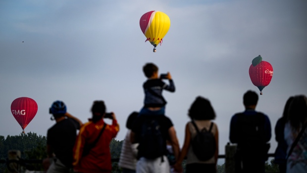 People watch hot air balloons rise into the air from the Sir George Etienne Cartier Parkway in Ottawa, during the Gatineau Hot Air Balloon Festival, on Monday, Sept. 4, 2023. (Justin Tang/THE CANADIAN PRESS)