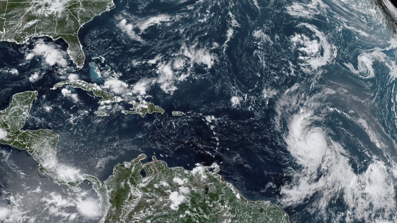 This Wednesday, Sept. 6, 2023, satellite image provided by the National Oceanic and Atmospheric Administration shows Hurricane Lee, right, off in the central tropical Atlantic Ocean. (NOAA via AP)