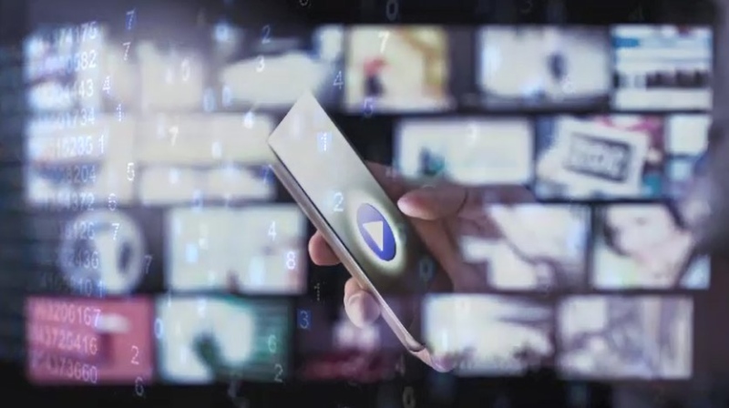A graphic depicts a person using a cell phone with blurred TV/computer screens in the background. (CTV News London) 