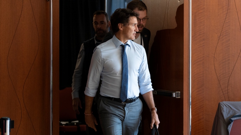 Prime Minister Justin Trudeau speaks to a member of his staff while leaving a meeting at the Liberal cabinet retreat in Charlottetown, P.E.I. on Wednesday, August 23, 2023. THE CANADIAN PRESS/Darren Calabrese