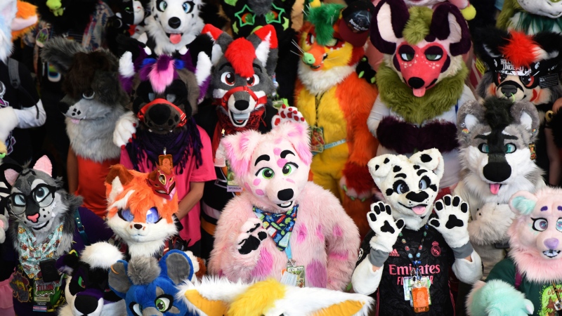 Furries pose for the annual Fursuit Group Photo at the Anthrocon Convention at David L. Lawrence Convention Center on Saturday, June 2, 2022, in downtown Pittsburgh. Furries shut down the street of Penn Avenue between 9th and 11th streets for their annual Fursuit Parade and Block Party. (Maya Giron/Pittsburgh Post-Gazette via AP)