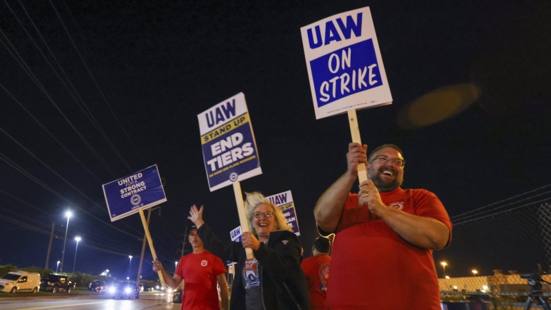 Picketers stand next to a road outside the Stellantis Toledo Assembly Complex early Friday, Sept. 15, 2023, in Toledo, Ohio.  (Jonathan Aguilar/The Blade via AP)
