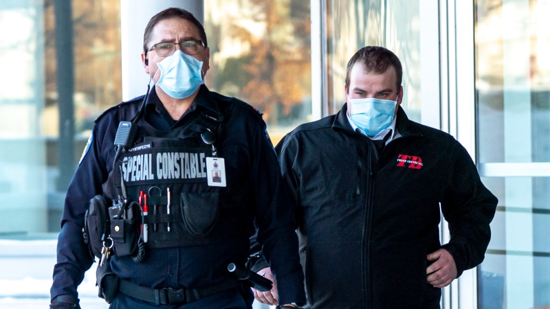 Brayden Bushby, right, departs the courthouse with a police officer after his sentencing hearing after being found guilty of manslaughter in the death of Barbara Kentner, in Thunder Bay, Ont., on Wednesday February 17, 2021. THE CANADIAN PRESS/David Jackson