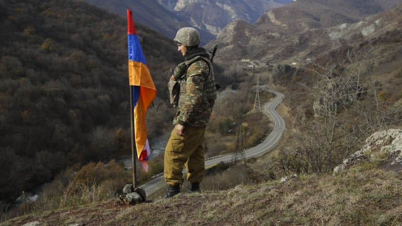 In this Wednesday, Nov. 25, 2020 file photo, an ethnic Armenian soldier stands guard next to Nagorno-Karabakh's flag atop of the hill. (AP Photo/Sergei Grits, File)