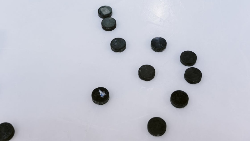 Hockey pucks are shown on the ice in a file image. (Pexels/Tima Miroshnichenko)