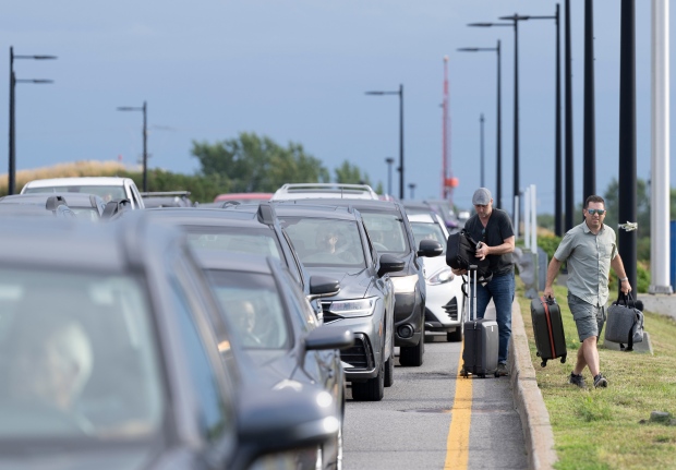Travellers exit their rides on the road as they try to make their flight to Toronto with their luggage at the Pierre Elliott Trudeau airport, in Montreal, Thursday, Sept. 7, 2023. THE CANADIAN PRESS/Christinne Muschi