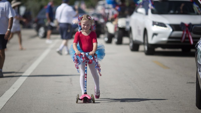Nayeli Eagles rides her scooter during the annual parade in Lauderdale by the Sea, Fla., Friday, July 4, 2014. City officials invited kids to decorate their bikes for the parade. (J Pat Carter/AP Photo)