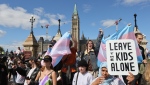 Protesters hold signs in front of counter-protestors at a demonstration against sexual orientation and gender identity programs in schools, in front of Parliament Hill in Ottawa on Wednesday, Sept. 20, 2023. The protest was one of many across Canada, organized by "1MillionMarch4Children," as they protest against so-called "gender ideology" being taught in schools. THE CANADIAN PRESS/ Patrick Doyle